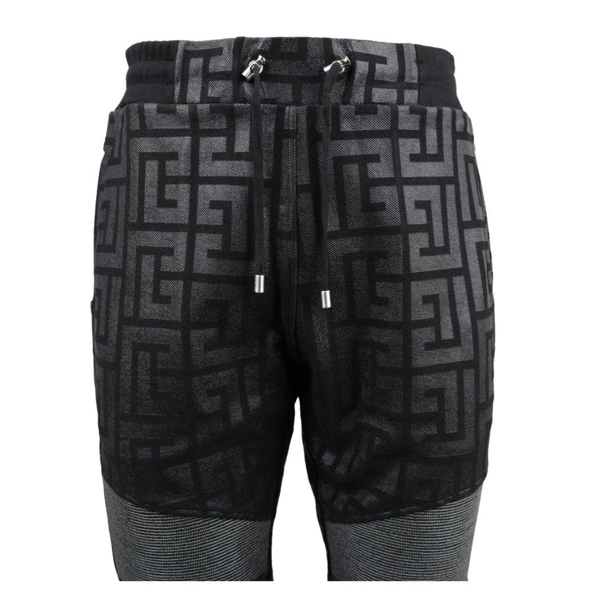 Black Cotton Men Jogging PantStep into the ultimate fusion of comfort and high-fashion with these Balmain black cotton jogging pants. Flaunting a bold all-over pattern print that ensures you’ll stand out in any crowd, these joggers are an essential update