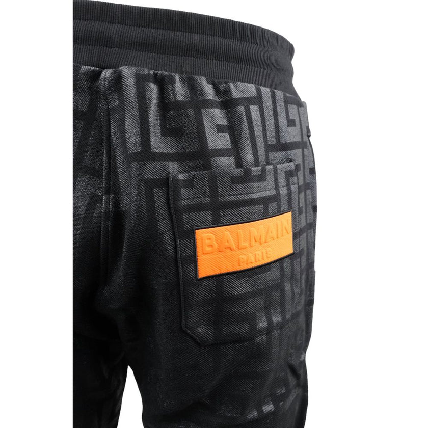 Black Cotton Men Jogging PantStep into the ultimate fusion of comfort and high-fashion with these Balmain black cotton jogging pants. Flaunting a bold all-over pattern print that ensures you’ll stand out in any crowd, these joggers are an essential update
