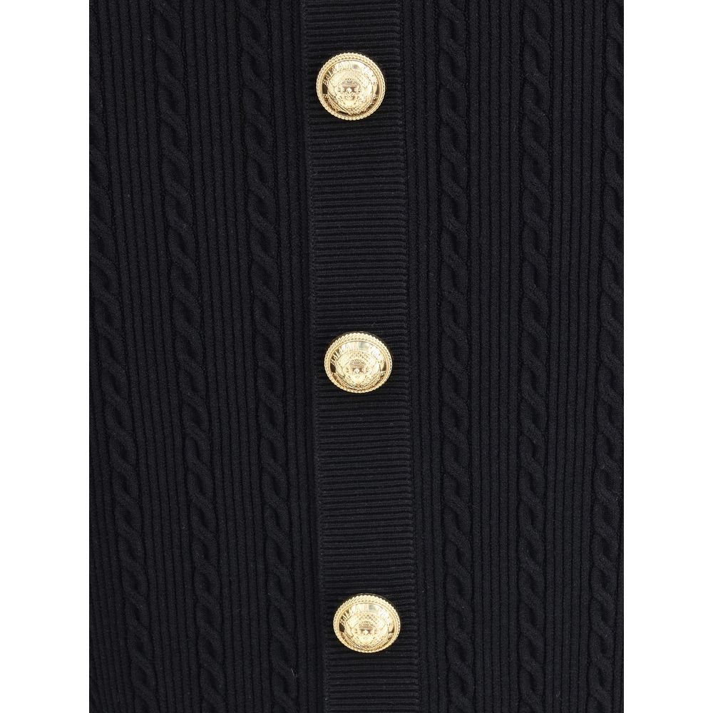 Gold Viscose Midi SkirtBalmain’s midi Skirt enhances the silhouette with a ribbed and twisted knit, giving structure and movement to the garment. On the front, the characteristic decorative 