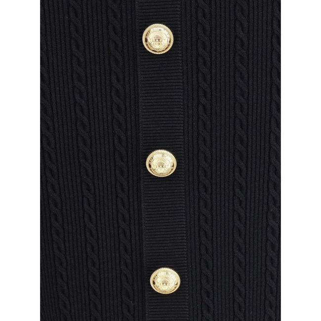 Gold Viscose Midi SkirtBalmain’s midi Skirt enhances the silhouette with a ribbed and twisted knit, giving structure and movement to the garment. On the front, the characteristic decorative 