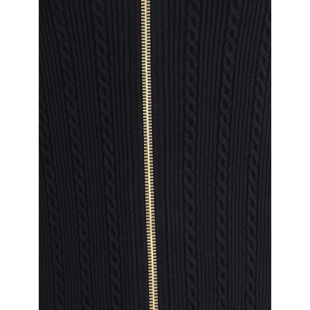 Gold Viscose Midi SkirtBalmain’s midi Skirt enhances the silhouette with a ribbed and twisted knit, giving structure and movement to the garment. On the front, the characteristic decorative 