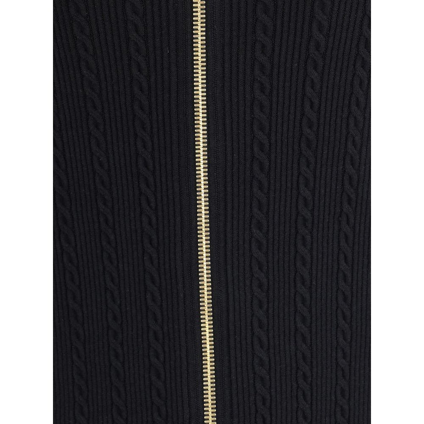 Gold Viscose Midi SkirtBalmain’s midi Skirt enhances the silhouette with a ribbed and twisted knit, giving structure and movement to the garment. On the front, the characteristic decorative 