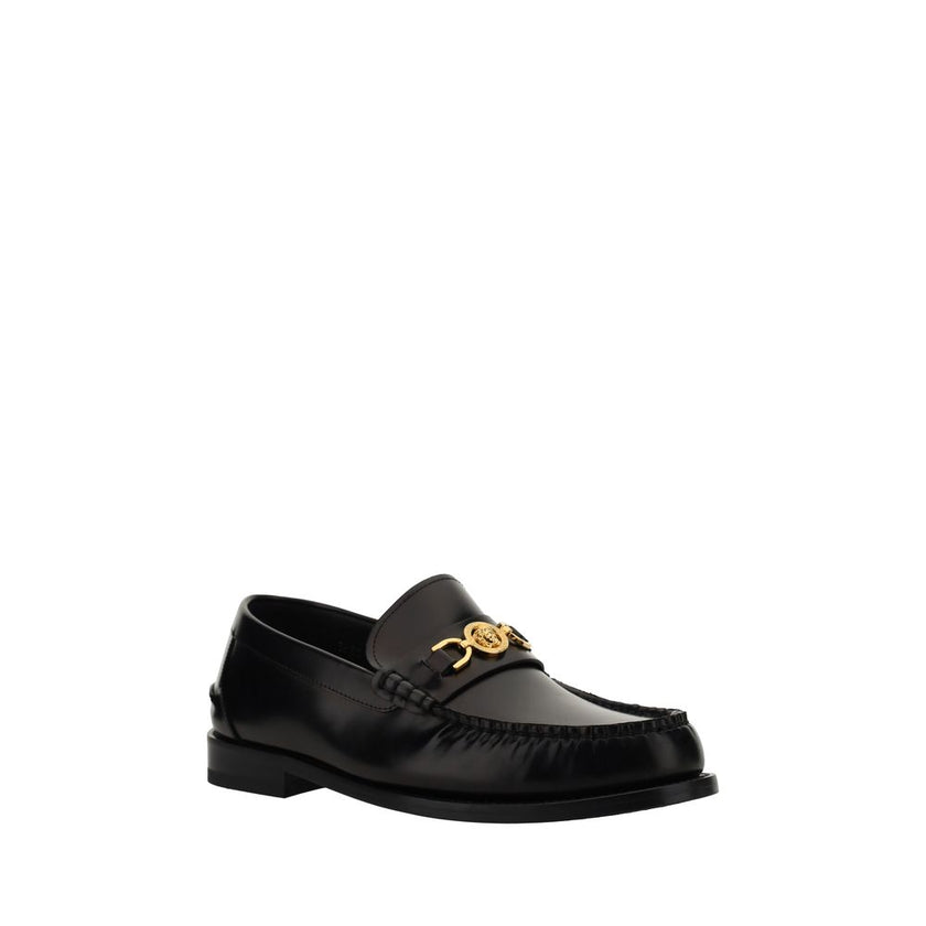 Black Calf Leather Bos Taurus Slip-On LoafersVersace’s leather Loafers combine classic elegance with iconic details. Featuring a slightly elongated round toe and a leather block heel, they feature a front tray embellished with a plaque featuring the iconi