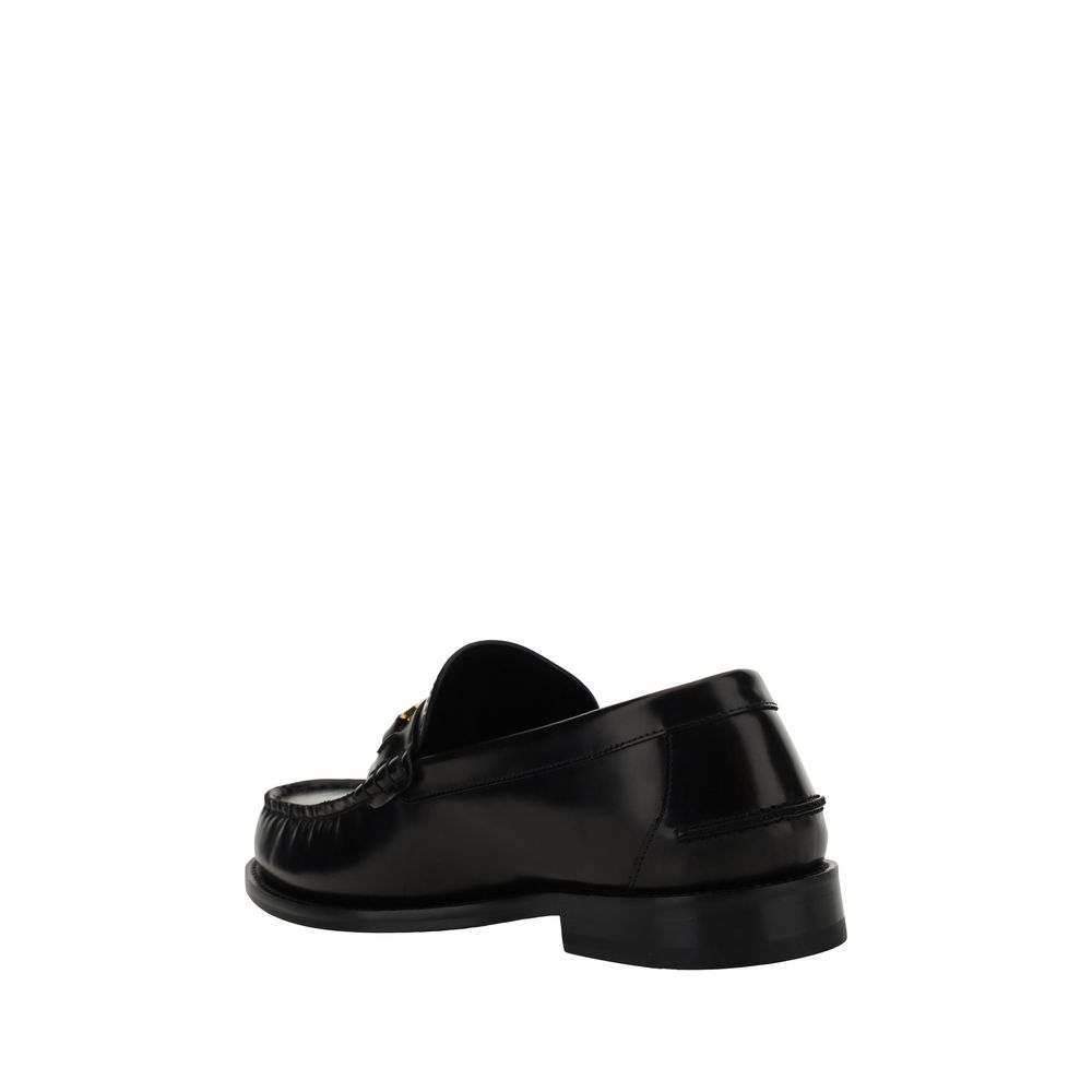 Black Calf Leather Bos Taurus Slip-On LoafersVersace’s leather Loafers combine classic elegance with iconic details. Featuring a slightly elongated round toe and a leather block heel, they feature a front tray embellished with a plaque featuring the iconi