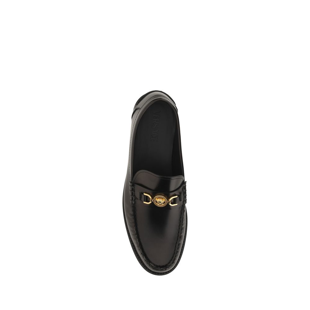 Black Calf Leather Bos Taurus Slip-On LoafersVersace’s leather Loafers combine classic elegance with iconic details. Featuring a slightly elongated round toe and a leather block heel, they feature a front tray embellished with a plaque featuring the iconi
