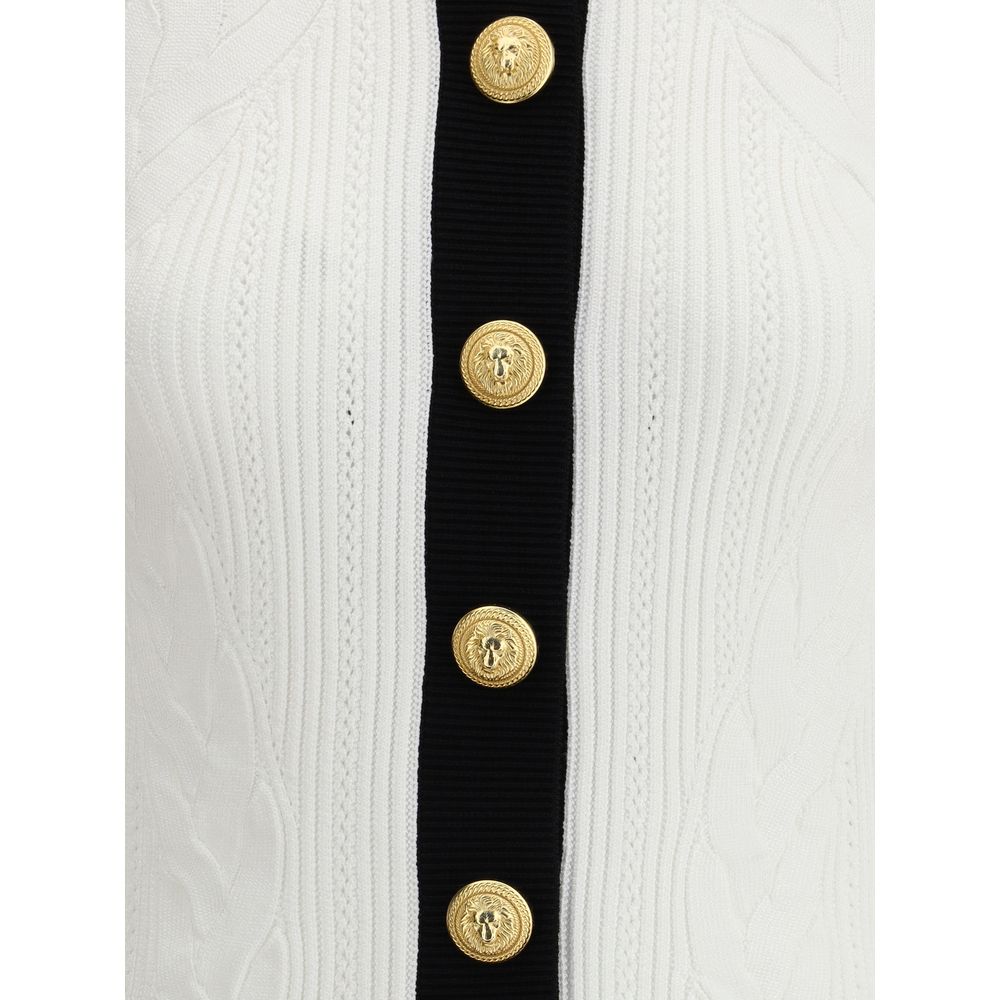 White Viscose CardiganBalmain’s Contrast Trim Cardigan features a ribbed and braided design enhanced by a silhouette-defining ribbed crew neck and hem. The front closure is embellished with embossed gold buttons, an iconic detail that adds a touch of luxu