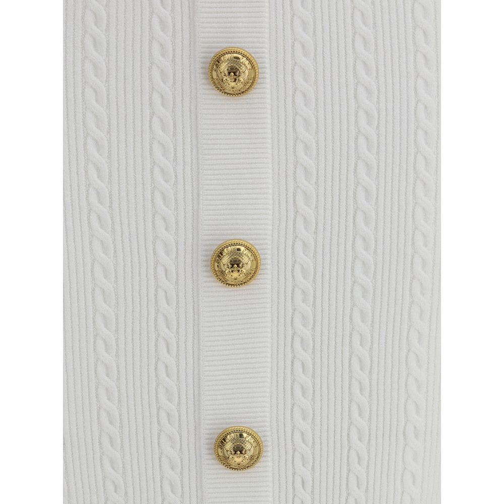 White Viscose Midi SkirtBalmain’s midi Skirt enhances the silhouette with a ribbed and twisted knit, giving structure and movement to the garment. On the front, the characteristic decorative 