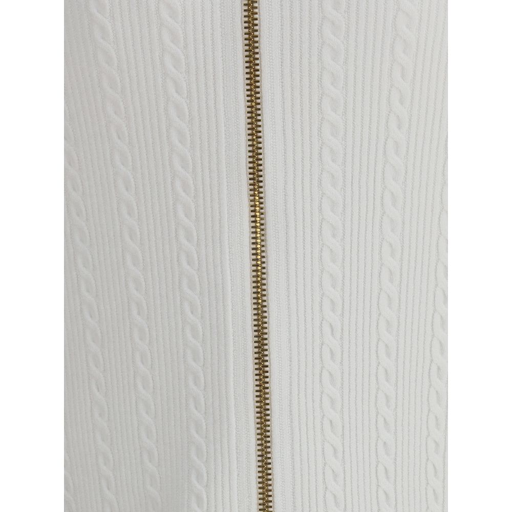 White Viscose Midi SkirtBalmain’s midi Skirt enhances the silhouette with a ribbed and twisted knit, giving structure and movement to the garment. On the front, the characteristic decorative 