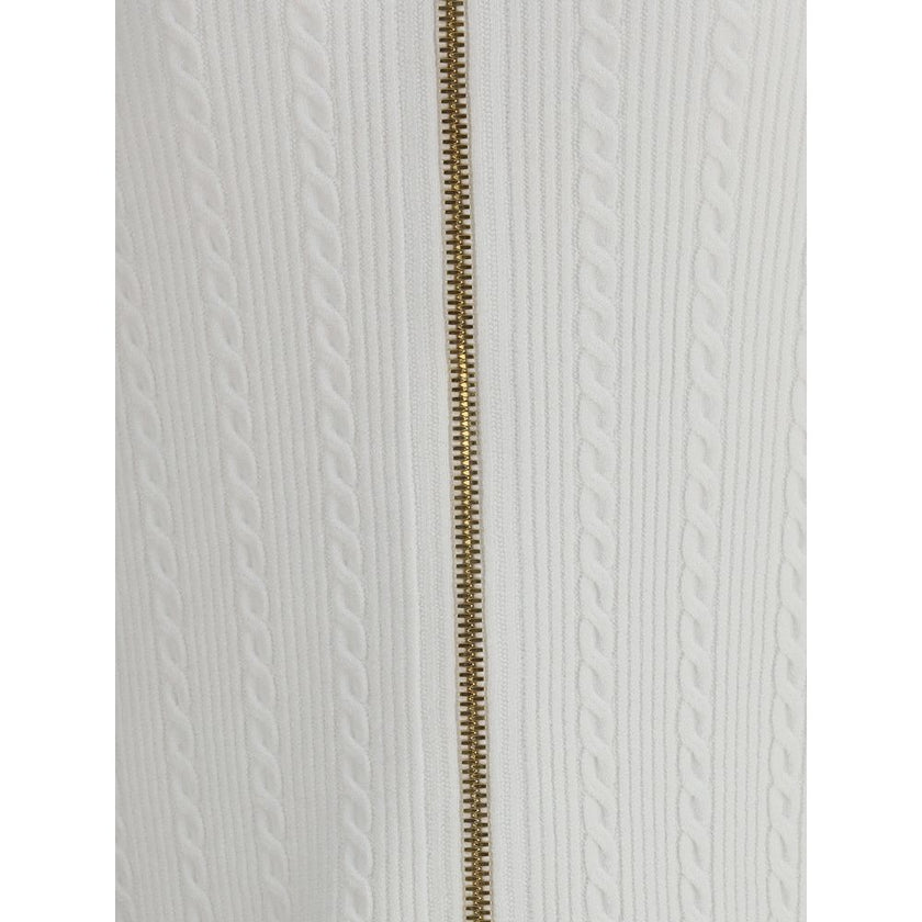 White Viscose Midi SkirtBalmain’s midi Skirt enhances the silhouette with a ribbed and twisted knit, giving structure and movement to the garment. On the front, the characteristic decorative 