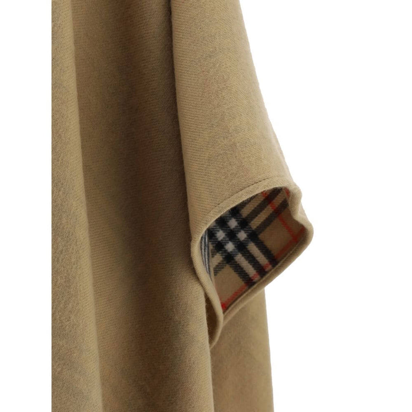 Brown Merino Wool CoatMerino Wool Cape by Burberry, monochrome cape design, shawl lapels, frayed hem, patterned Archivio Check interior, oversize fit. Season: AW25 Composition: GENERAL 100% Merino Wool MADE IN GREAT BRITAINBrown Merino Wool Coat${tagsBurb