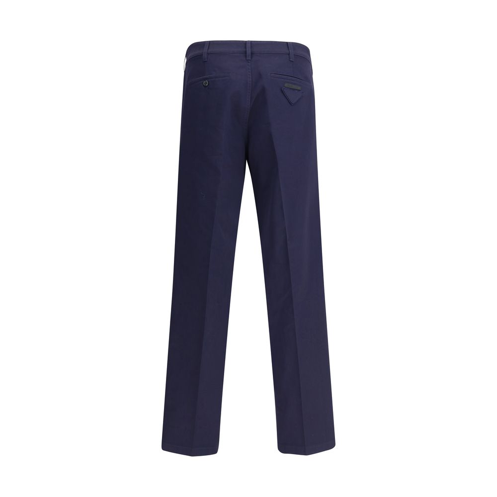 Blue Cotton Chino PantsPrada’s chino Pants offer essential elegance with contemporary style. Featuring a front zipper and button closure, they feature two side welt pockets and back pockets, one of which is embellished with the brand’s iconic logo. Waist