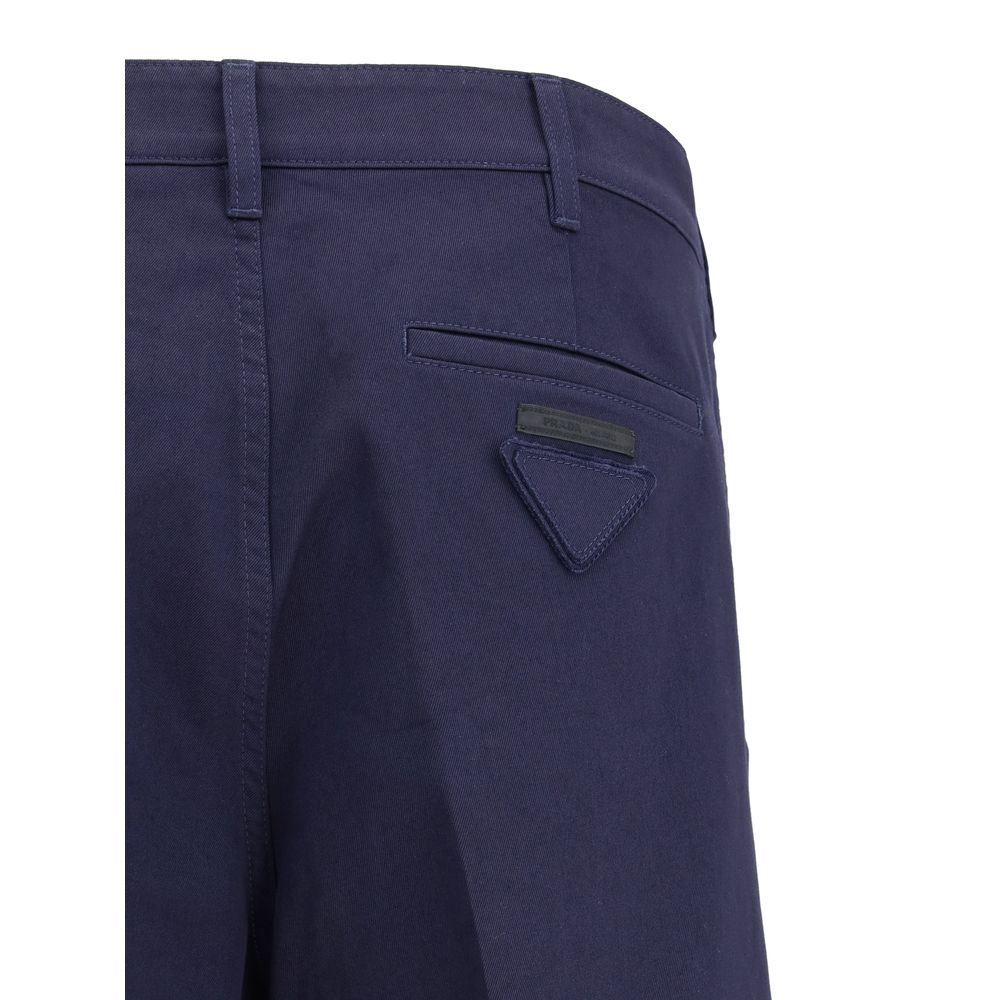 Blue Cotton Chino PantsPrada’s chino Pants offer essential elegance with contemporary style. Featuring a front zipper and button closure, they feature two side welt pockets and back pockets, one of which is embellished with the brand’s iconic logo. Waist