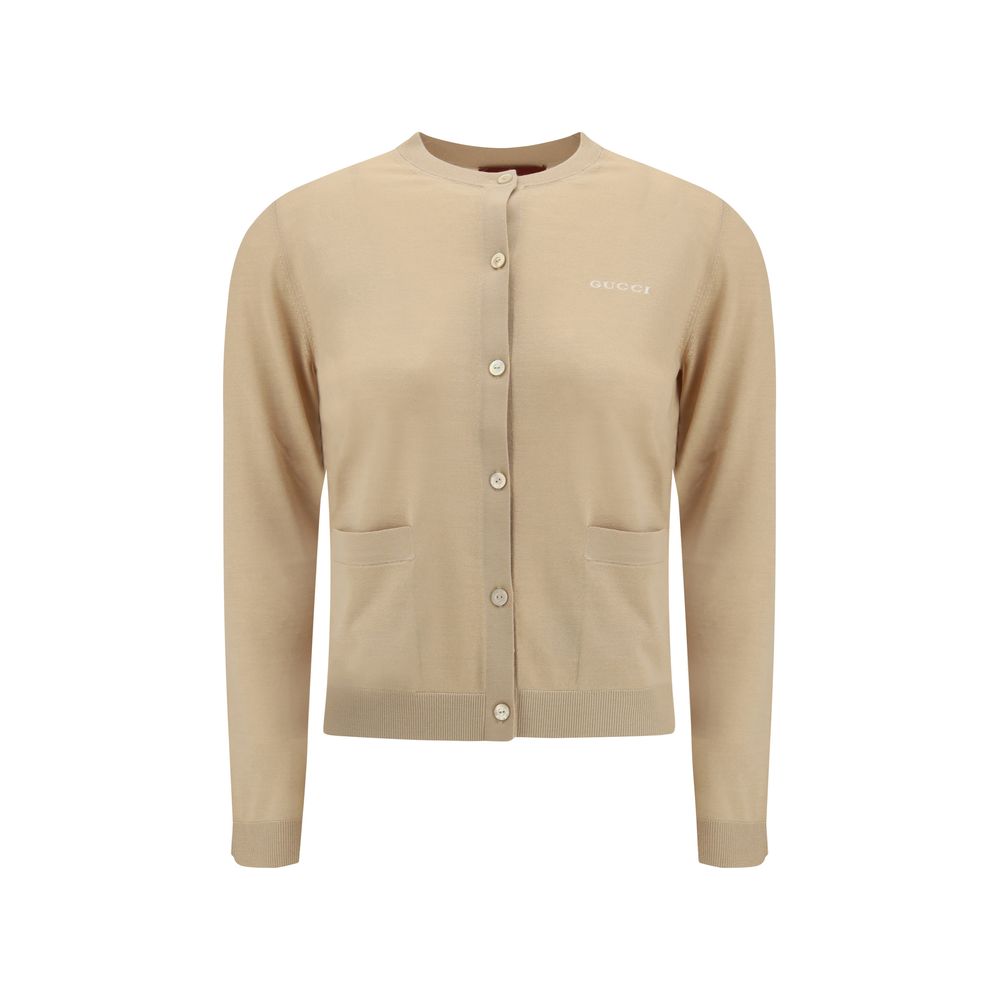 Beige Cashmere CardiganGucci’s cashmere Cardigan is a timeless garment, the epitome of elegance and comfort. Featuring a ribbed crew neck, hem and cuffs, it has a front button closure and two small patch pockets on the front. The iconic stitched signature