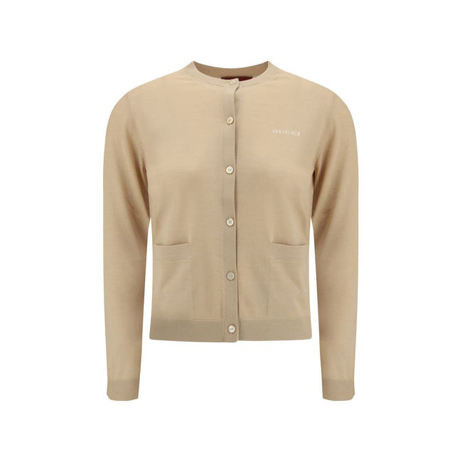 Beige Cashmere CardiganGucci’s cashmere Cardigan is a timeless garment, the epitome of elegance and comfort. Featuring a ribbed crew neck, hem and cuffs, it has a front button closure and two small patch pockets on the front. The iconic stitched signature
