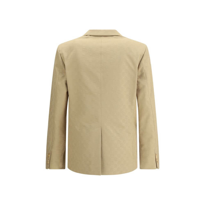 Beige Cotton BlazerGucci’s GG jacquard blazer is an elegant and distinctive piece made of jacquard fabric with the iconic GG pattern. Fully lined, it features a single-breasted button closure, notch lapels, a chest pocket and two front pockets. A perfect