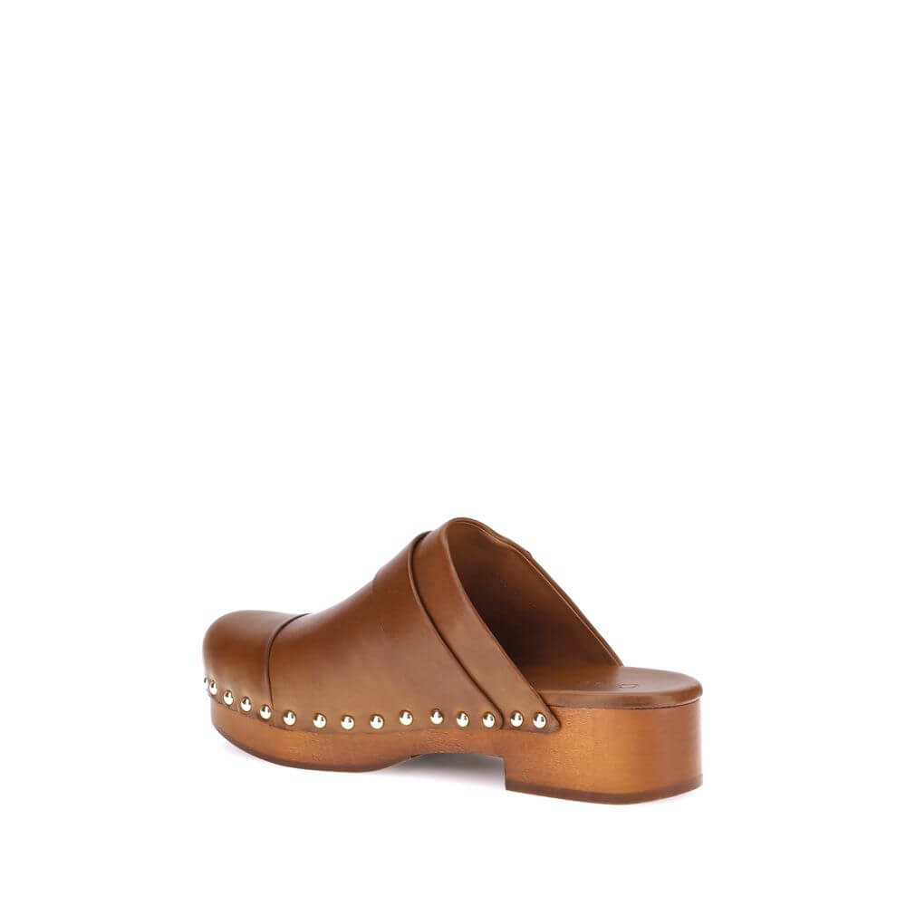 Brown Calf Leather Bos Taurus ClogsChloé’s Jeannette Mules reinterpret the classic clog model with a bold, contemporary style. Made of soft calfskin, they feature a solid wooden platform and a low wide heel for stability and comfort. The round toe, golden