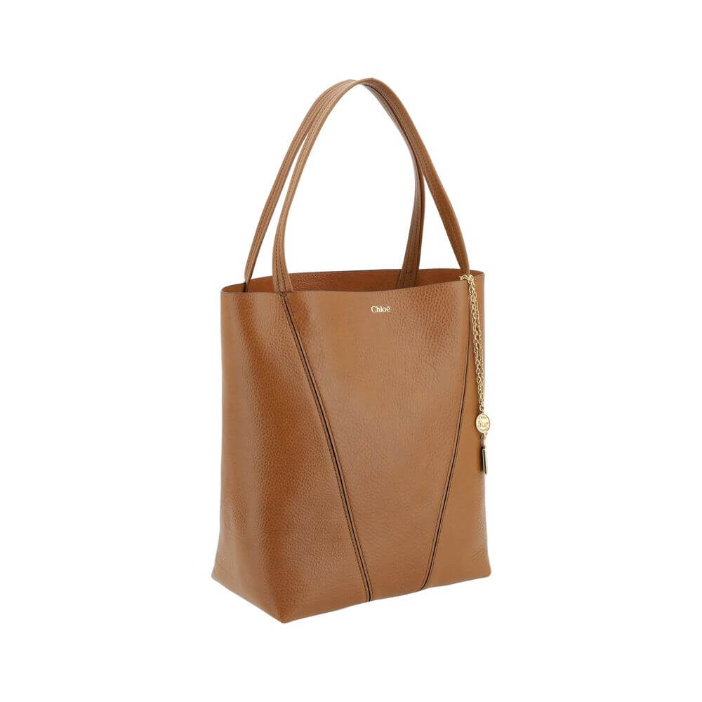 Brown Calf Leather Bos Taurus Shoulder BagLeather Spin Shoulder Bag by Chloé is a refined and modern accessory featuring a sleek grained leather design. The two flat top handles offer a comfortable and practical grip, while the brand’s iconic monogram, pr