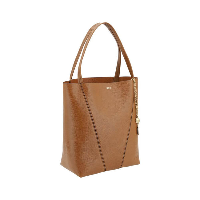 Brown Calf Leather Bos Taurus Shoulder BagLeather Spin Shoulder Bag by Chloé is a refined and modern accessory featuring a sleek grained leather design. The two flat top handles offer a comfortable and practical grip, while the brand’s iconic monogram, pr