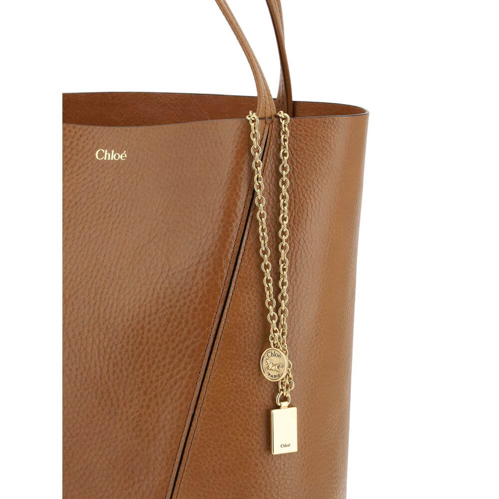 Brown Calf Leather Bos Taurus Shoulder BagLeather Spin Shoulder Bag by Chloé is a refined and modern accessory featuring a sleek grained leather design. The two flat top handles offer a comfortable and practical grip, while the brand’s iconic monogram, pr
