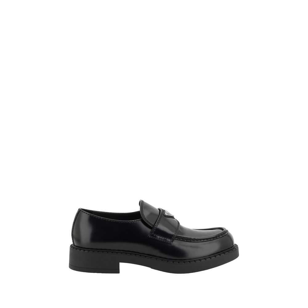 Black Rubber Platform LoafersPrada’s Leather Loafers revisit a classic with a bold, contemporary attitude. Featuring a slightly elongated round toe and a textured platform sole, they are distinguished by the iconic enameled triangular logo plaque applied