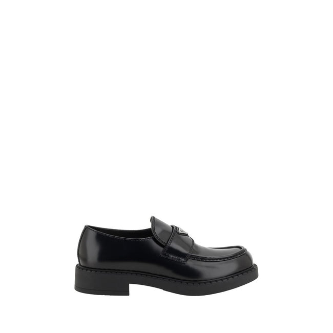 Black Rubber Platform LoafersPrada’s Leather Loafers revisit a classic with a bold, contemporary attitude. Featuring a slightly elongated round toe and a textured platform sole, they are distinguished by the iconic enameled triangular logo plaque applied