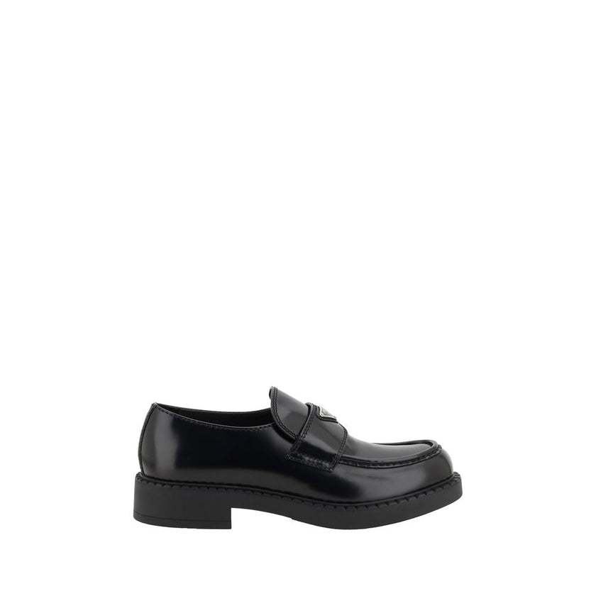 Black Rubber Platform LoafersPrada’s Leather Loafers revisit a classic with a bold, contemporary attitude. Featuring a slightly elongated round toe and a textured platform sole, they are distinguished by the iconic enameled triangular logo plaque applied