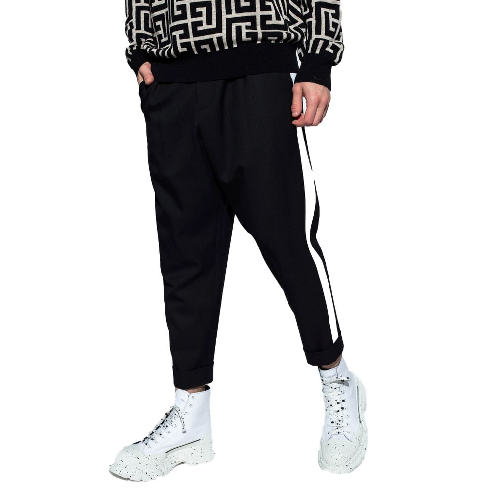 Black Cotton Men TrousersEmbark on a journey of sheer style and comfort with Balmain’s black cotton trousers. Adorned with striking white side stripes that command attention, these trousers are the epitome of modern elegance. Designed for the man who appr
