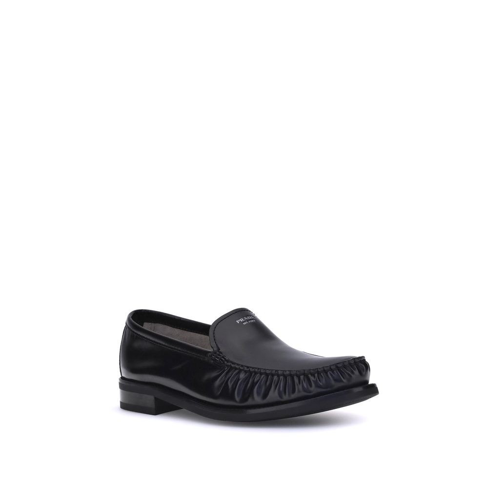 Black Calf Leather Bos Taurus Slip-On LoafersPrada’s brushed leather Loafers reinterpret a classic with a tapered, lightweight silhouette enhanced by the elegant finish of brushed leather. The refined handcrafted construction emphasizes the minimalist cha