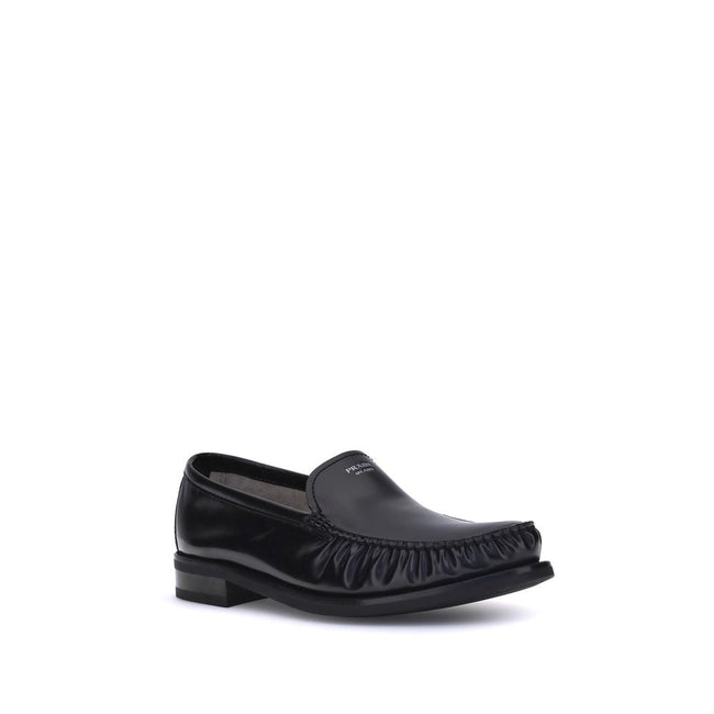 Black Calf Leather Bos Taurus Slip-On LoafersPrada’s brushed leather Loafers reinterpret a classic with a tapered, lightweight silhouette enhanced by the elegant finish of brushed leather. The refined handcrafted construction emphasizes the minimalist cha