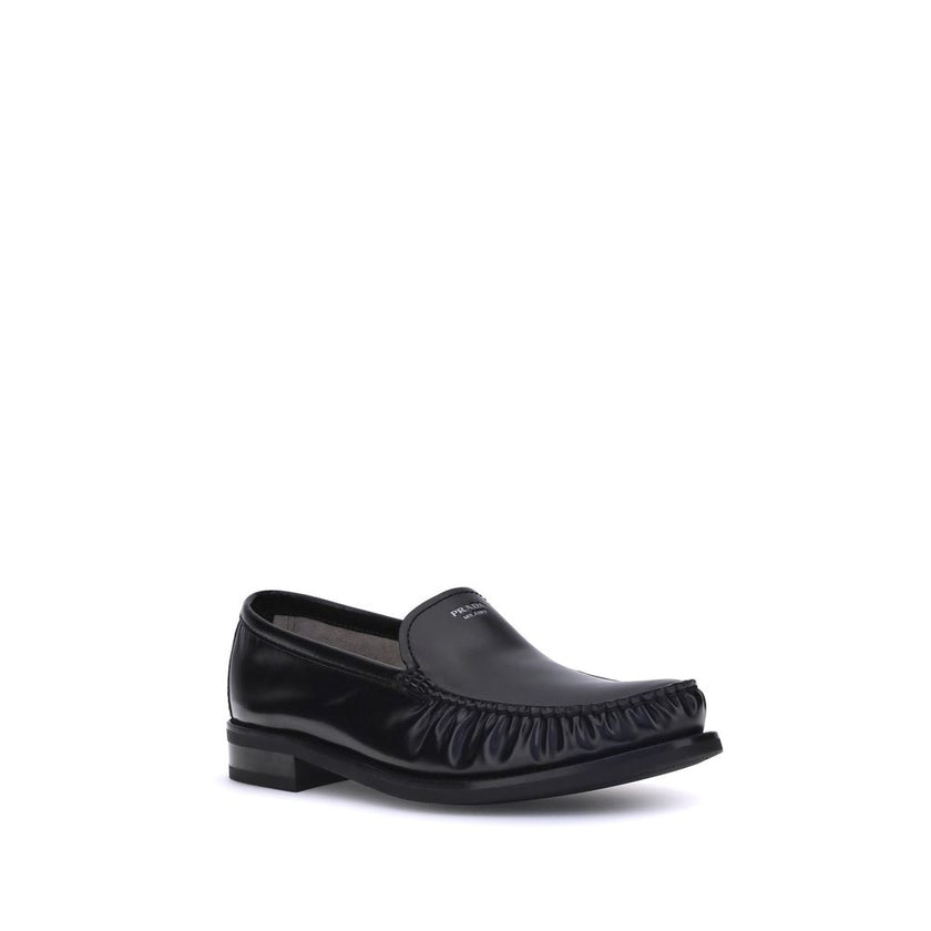 Black Calf Leather Bos Taurus Slip-On LoafersPrada’s brushed leather Loafers reinterpret a classic with a tapered, lightweight silhouette enhanced by the elegant finish of brushed leather. The refined handcrafted construction emphasizes the minimalist cha