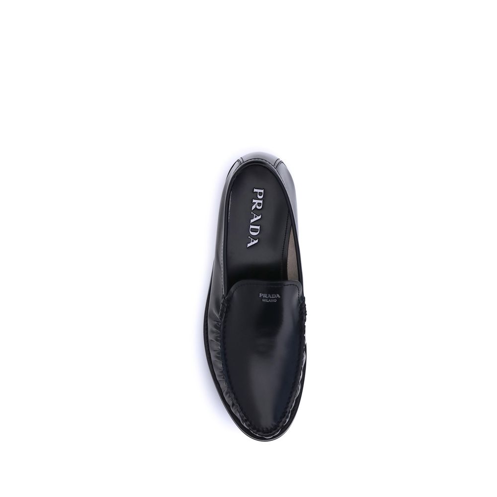 Black Calf Leather Bos Taurus Slip-On LoafersPrada’s brushed leather Loafers reinterpret a classic with a tapered, lightweight silhouette enhanced by the elegant finish of brushed leather. The refined handcrafted construction emphasizes the minimalist cha