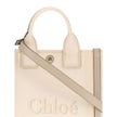Beige Cotton Shoulder BagChloé’s Carry Tote Bag is a stylish, multifunctional accessory made of cotton with contrasting leather details that accentuate its sophisticated appeal. Magnetic buttons on the side panels allow you to adjust the width of the bag
