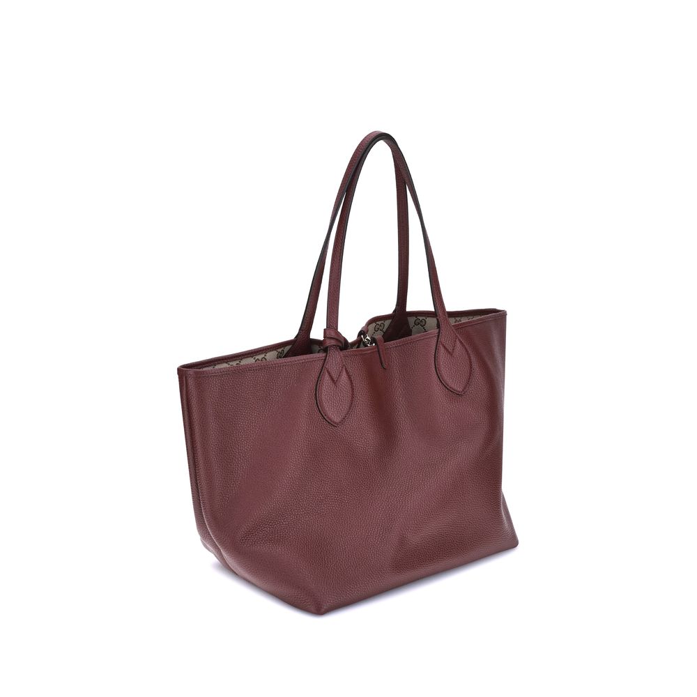 Bordeaux Calf Leather Bos Taurus Shoulder BagGucci’s reversible Totissima Tote Bag is an iconic accessory that combines versatility and luxury. Extremely functional, it stands out for its ability to be worn two ways: one side features elegant black graine