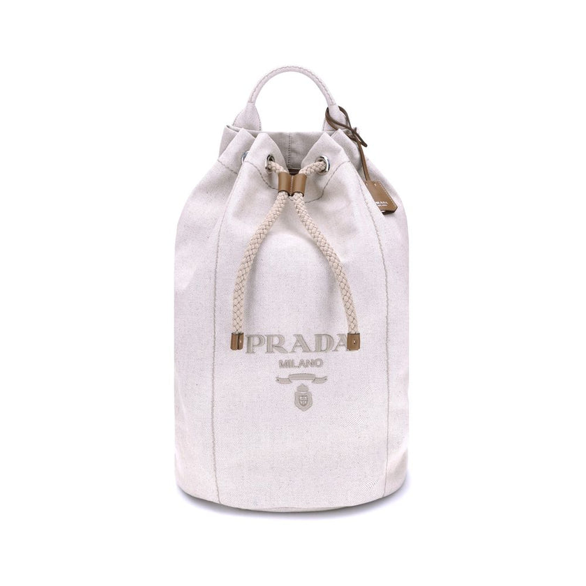 White Cotton Backet BagPrada’s Linen Bucket Bag features a lightweight design with a sporty character. It features a linen handle and an adjustable shoulder strap enhanced with leather details and the iconic tone-on-tone embroidered logo that gives the ac