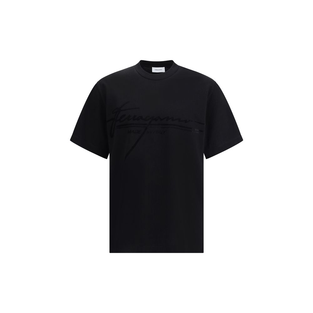 Black Cotton T-ShirtFerragamo’s cotton T-Shirt stands out for its minimal elegance and refined details. Made of soft cotton, it features a ribbed crew neck and the brand’s iconic tone-on-tone signature on the front for a discreet and sophisticated effect.