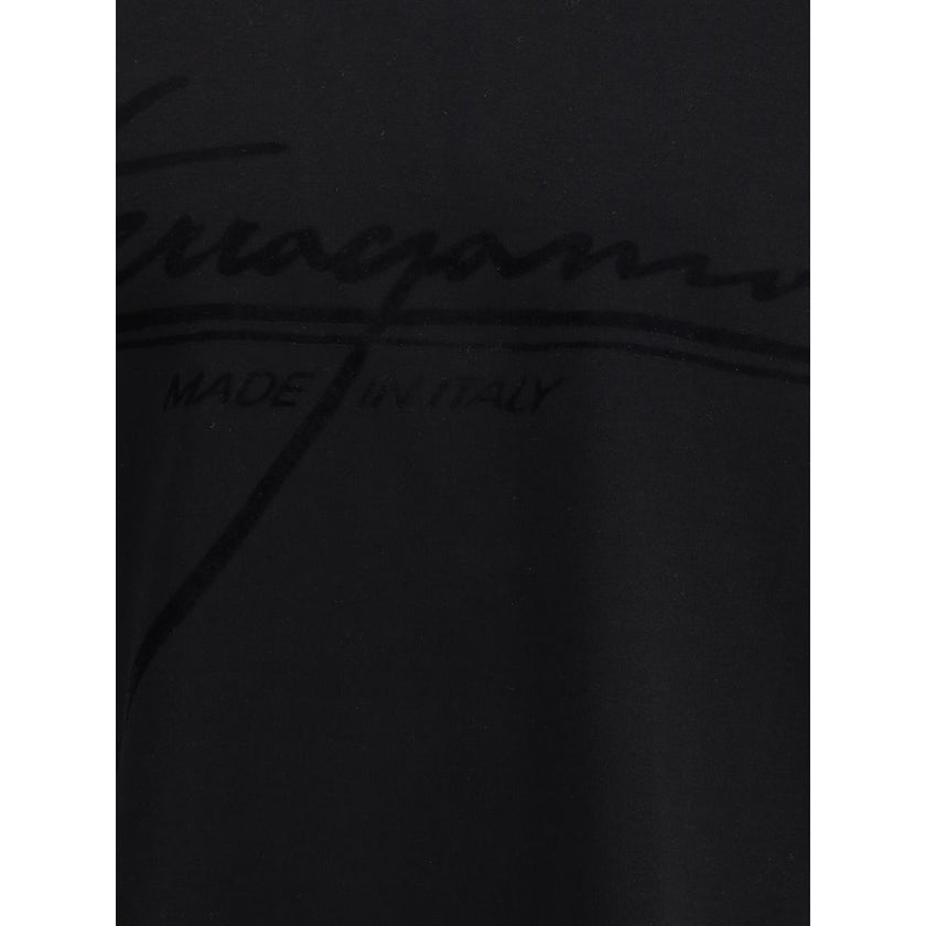 Black Cotton T-ShirtFerragamo’s cotton T-Shirt stands out for its minimal elegance and refined details. Made of soft cotton, it features a ribbed crew neck and the brand’s iconic tone-on-tone signature on the front for a discreet and sophisticated effect.