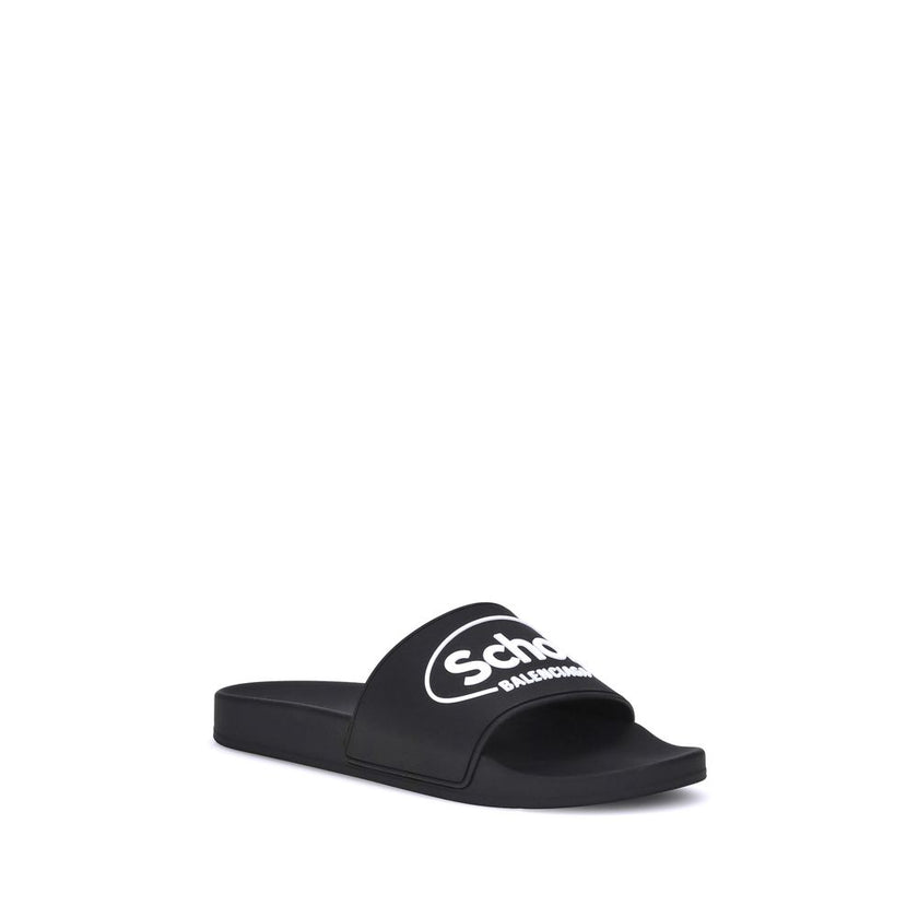 Black Rubber Flat SandalsThe Sholl X Balenciaga Rubber Slippers feature a flat sole and the iconic contrasting logo on the front band, combining comfort and distinctive design in a casual, contemporary style. Season: AW25 Composition: 100% Rubber MADE IN