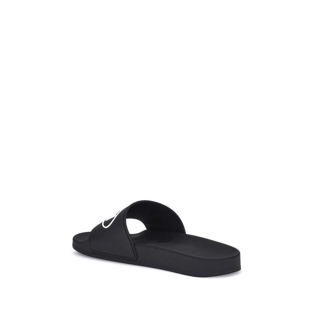 Black Rubber Flat SandalsThe Sholl X Balenciaga Rubber Slippers feature a flat sole and the iconic contrasting logo on the front band, combining comfort and distinctive design in a casual, contemporary style. Season: AW25 Composition: 100% Rubber MADE IN