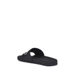 Black Rubber Flat SandalsThe Sholl X Balenciaga Rubber Slippers feature a flat sole and the iconic contrasting logo on the front band, combining comfort and distinctive design in a casual, contemporary style. Season: AW25 Composition: 100% Rubber MADE IN
