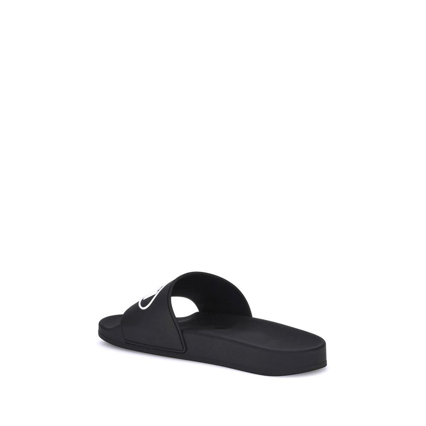 Black Rubber Flat SandalsThe Sholl X Balenciaga Rubber Slippers feature a flat sole and the iconic contrasting logo on the front band, combining comfort and distinctive design in a casual, contemporary style. Season: AW25 Composition: 100% Rubber MADE IN
