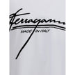 White Cotton T-ShirtFerragamo’s cotton T-Shirt is an essential piece with a clean, refined design. Featuring a ribbed crew neck, it features the brand’s iconic signature printed in contrast on the front for an understated yet distinctive look. Season: AW2