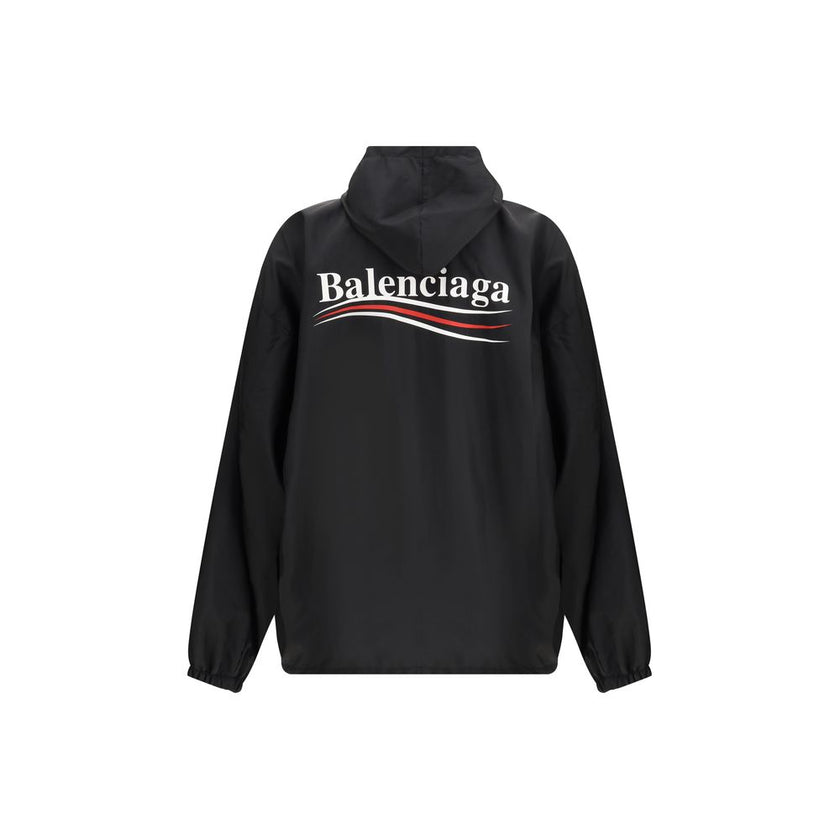 Black Polyester Shell JacketBalenciaga’s Waterproof Jacket is a functional garment with an essential design. Equipped with a hood, it features a front zipper and snap-button closure. The printed logo on the front and back adds an iconic touch, while the t