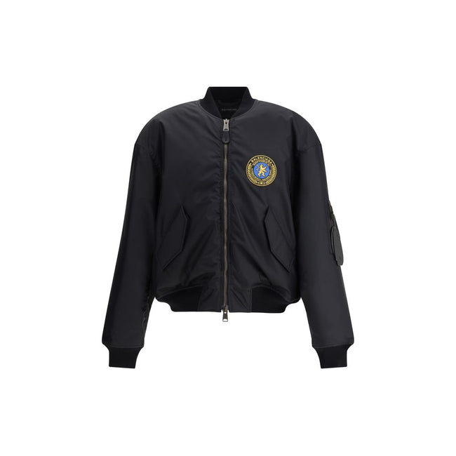 Black Polyamide BomberBalenciaga’s bomber Jacket features a zipper and pull tab closure, complemented by two flap pockets with snap buttons at the front. Ribbed edges define the garment’s profile, while a uniform chest applique adds a distinctive detail t