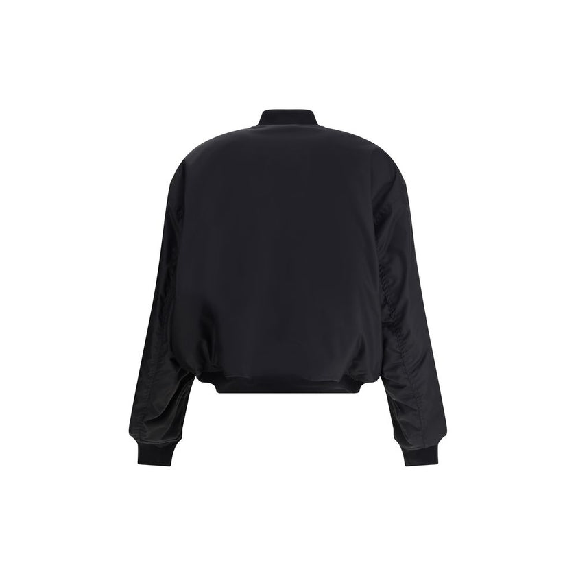 Black Polyamide BomberBalenciaga’s bomber Jacket features a zipper and pull tab closure, complemented by two flap pockets with snap buttons at the front. Ribbed edges define the garment’s profile, while a uniform chest applique adds a distinctive detail t