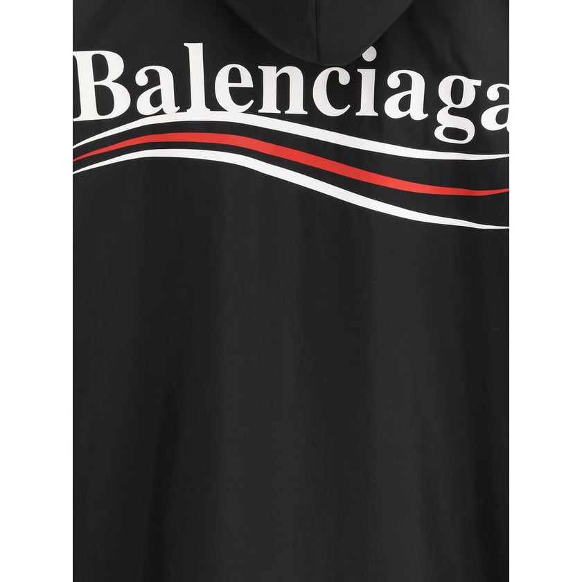 Black Polyester Shell JacketBalenciaga’s Waterproof Jacket is a functional garment with an essential design. Equipped with a hood, it features a front zipper and snap-button closure. The printed logo on the front and back adds an iconic touch, while the t