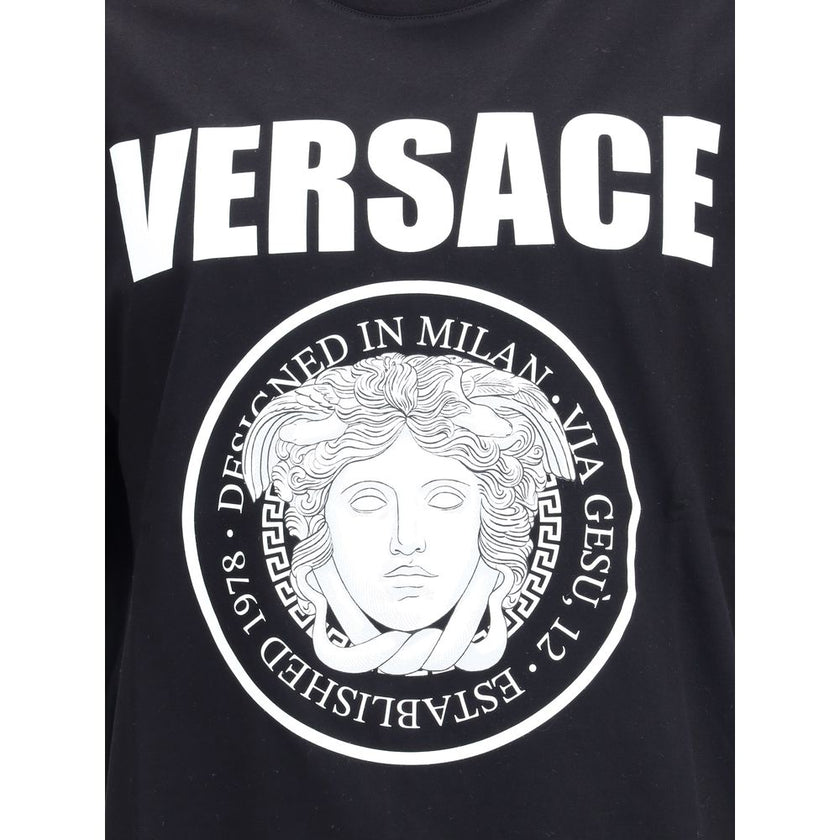 Black Cotton T-ShirtCotton T-Shirt by Versace featuring a ribbed crew neck and iconic contrasting monogram on the front, embellished with a Medusa maxi head. A distinctive garment that combines comfort and bold style. Season: AW25 Fit: Regular Composition