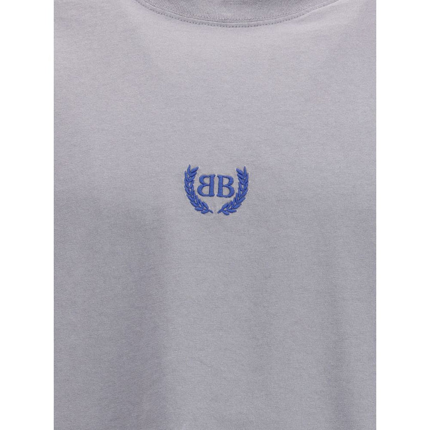 Gray Cotton T-ShirtBalenciaga’s cotton T-Shirt features a classic ribbed crew neck and the iconic BB logo embroidered on the front, adding a distinctive touch of luxury. The vintage worn-effect design gives the T-shirt a unique look, as if it has already