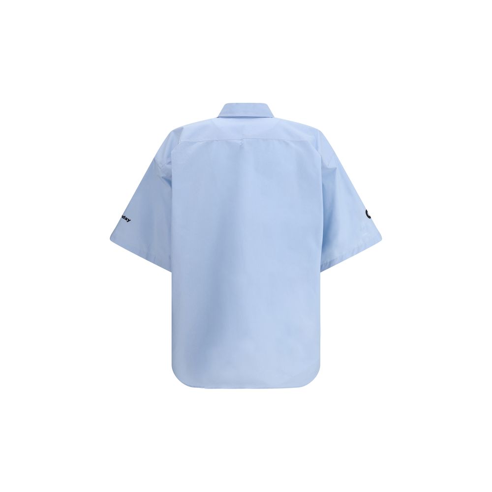 Light Blue Cotton Shortsleeve ShirtCotton Shirt by Balenciaga features a classic collar and front button closure. The short-sleeved design features an applique welt pocket on the front, while contrasting embroidered 