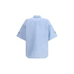 Light Blue Cotton Shortsleeve ShirtCotton Shirt by Balenciaga features a classic collar and front button closure. The short-sleeved design features an applique welt pocket on the front, while contrasting embroidered 