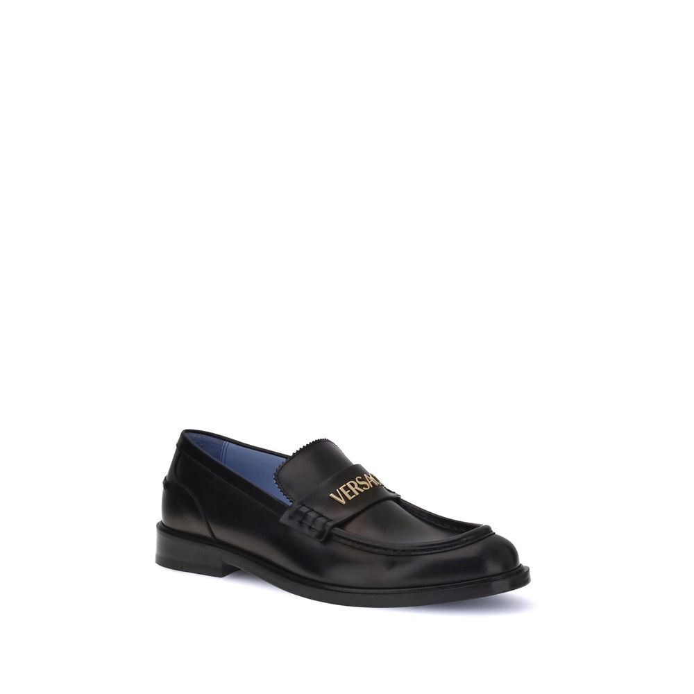 Black Calf Leather Bos Taurus Slip-On LoafersVersace’s Leather Loafers combine elegance and practicality in a slip-on design. Featuring a rounded toe, they feature the gold logo applied to the front tray, giving a distinctive and refined touch to this cla